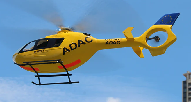 FLISHRC FL500 EC135 500-Class  Scale RC Helicopter – L7 Flight Controller, 4-Mode GPS Positioning rescue helicopter model flying outdoors, side view with spinning main rotor.