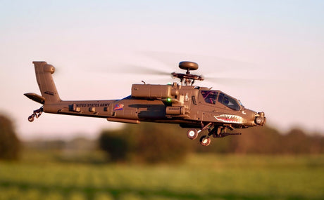 RC helicopter with military-style body flying steadily above an open field