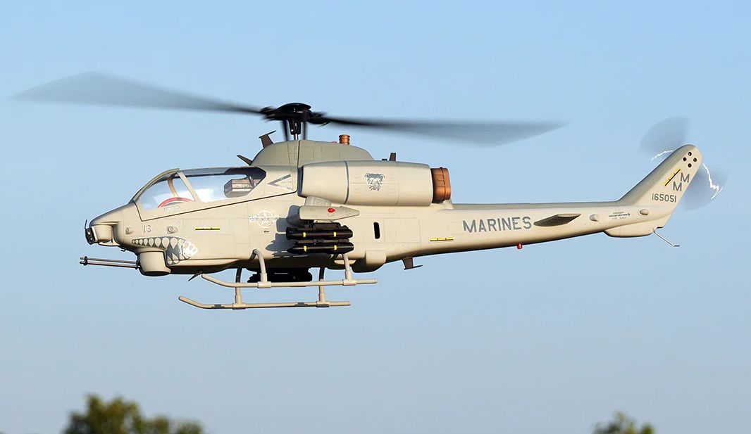 AH-1W Cobra Marine helicopter flying in a clear sky with visible rotor motion.